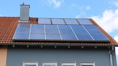 Auf dem Dach eines Hauses sind mehrere Solarpanels installiert, die in der Sonne glänzen und umweltfreundliche Energie erzeugen.