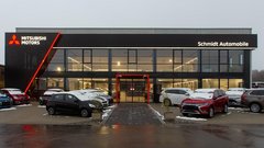 Das moderne Mitsubishi-Autohaus zeigt eine Vielzahl von Fahrzeugen, die auf dem Parkplatz mit leichtem Schnee bedeckt sind.