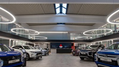 Ein modernes Autohaus mit mehreren Mitsubishi-Fahrzeugen, die in einem hellen, eleganten Raum ausgestellt sind.