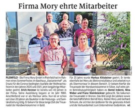 Sechs Mitarbeiter der Firma Mory stehen stolz mit Urkunden vor einem Gebäude, um ihre langjährige Treue zu feiern.
