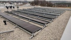 Eine große Anzahl von Solarpanelen ist auf einem Flachdach installiert, um erneuerbare Energie zu erzeugen.